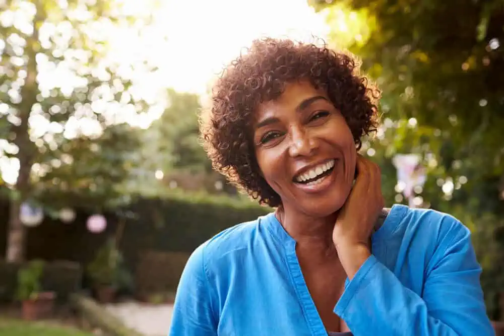 A woman outside in the sun smiling for the camera